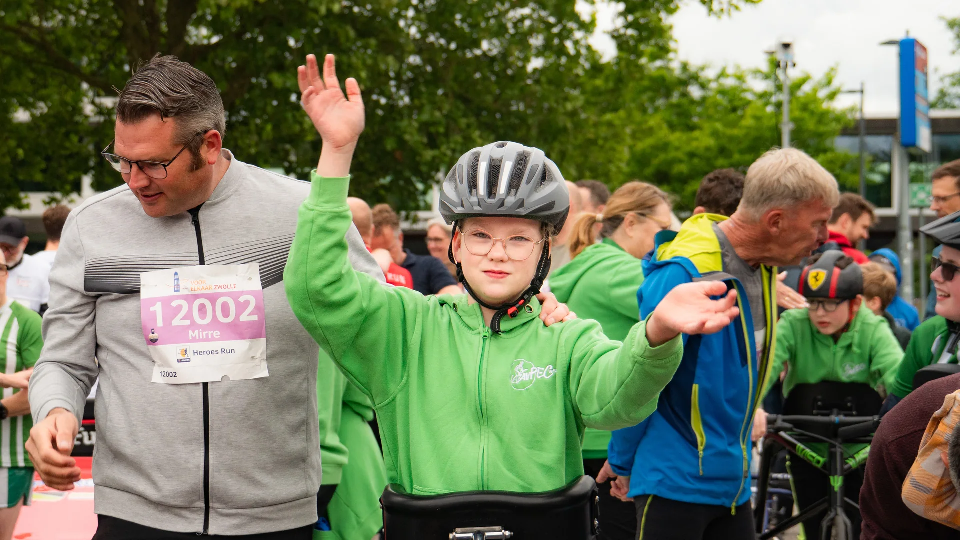 Een deelnemer aan de Heroes Run viert het lopen met opgeheven armen